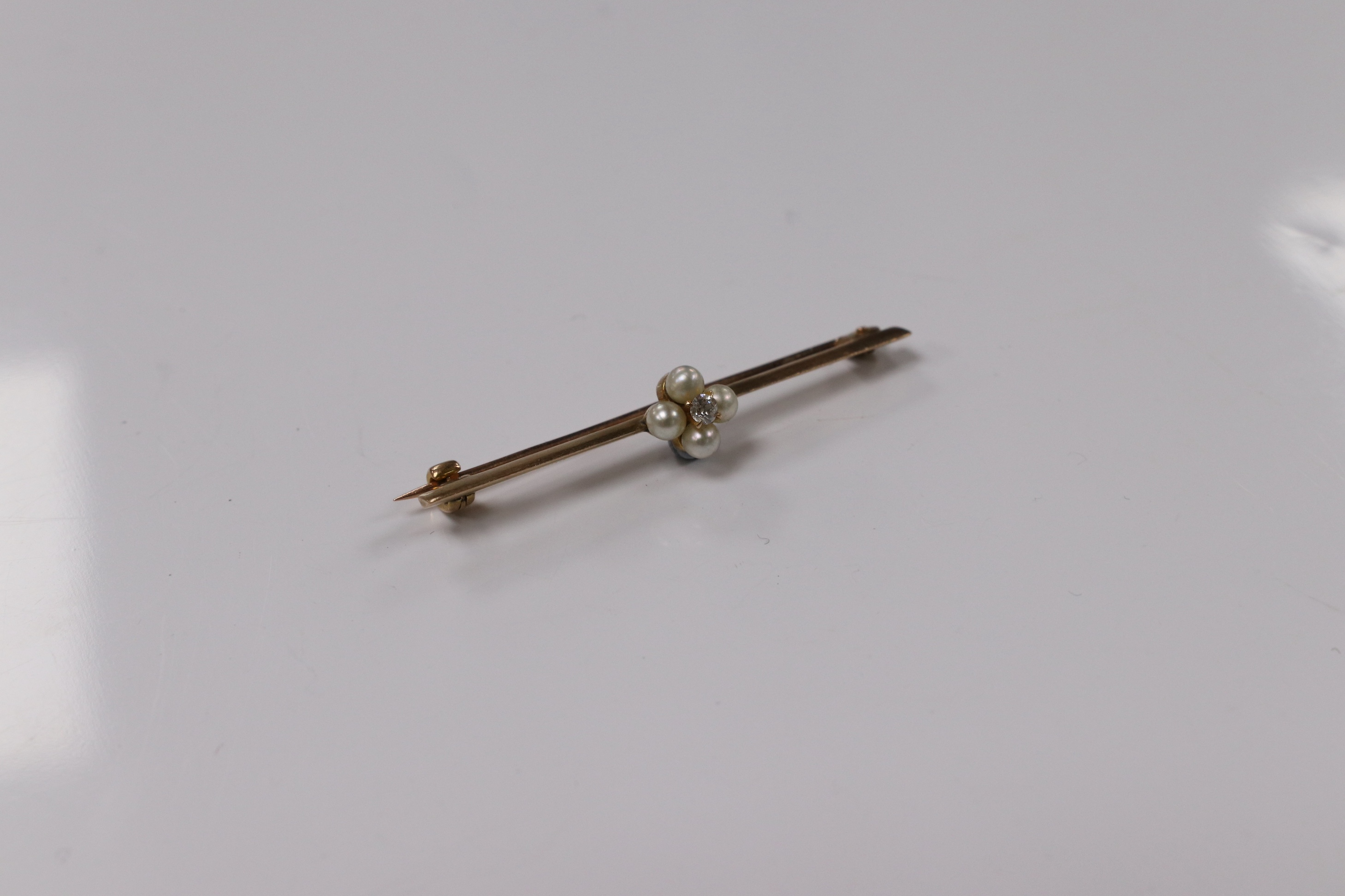 A yellow metal, diamond and seed pearl cluster set bar brooch, 44mm, gross weight 2.5 grams. Condition - fair to good